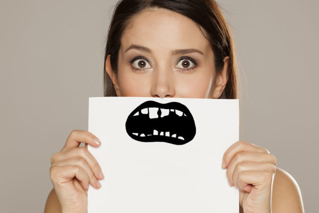 a woma hiding her smile learning how to prevent tooth decay