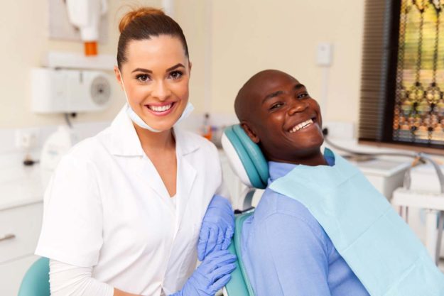 how-to-prevent-teeth-shifting (2) dentist smiling next to her patient who has prevented teeth shifting