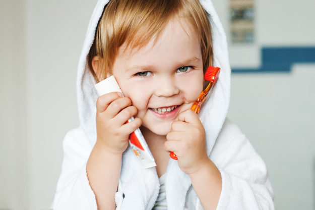 a child smiling as their parents wonder when should a child go to the dentist