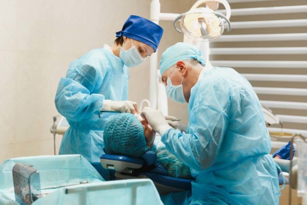 emergency-dentist-oral-surgeon dental patient getting procedure by the oral surgeon